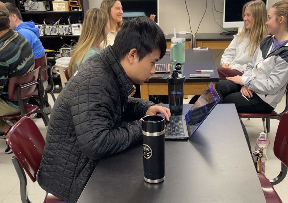Justin Dang coding on his laptop